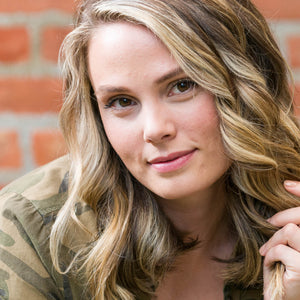 Woman with blonde hair smiling at the camera after using Vitamins Hair Growth Support Shampoo and Conditioner with Biotin