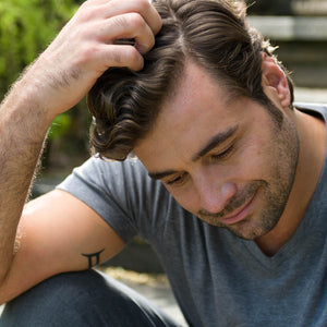 Man running fingers through his freshly washed hair 