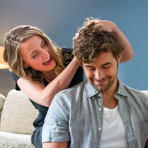 Woman ruffling her mans freshly washed full head of hair 