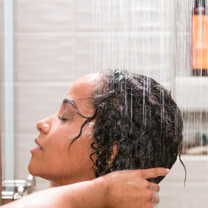 African American woman washing her hair in the shower